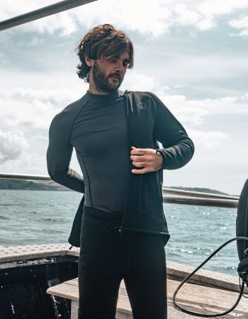 Diver putting on their Fourth Element Arctic two piece bundle